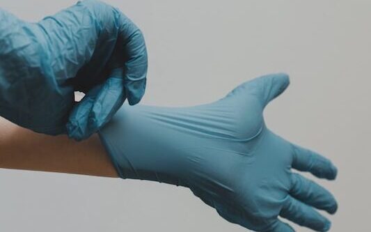person in blue gloves and blue denim jeans