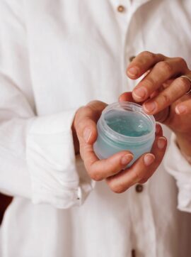 person holding blue plastic container, nutmeg oil benefits for skin