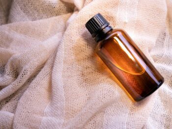 a bottle of perfume sitting on top of a white cloth